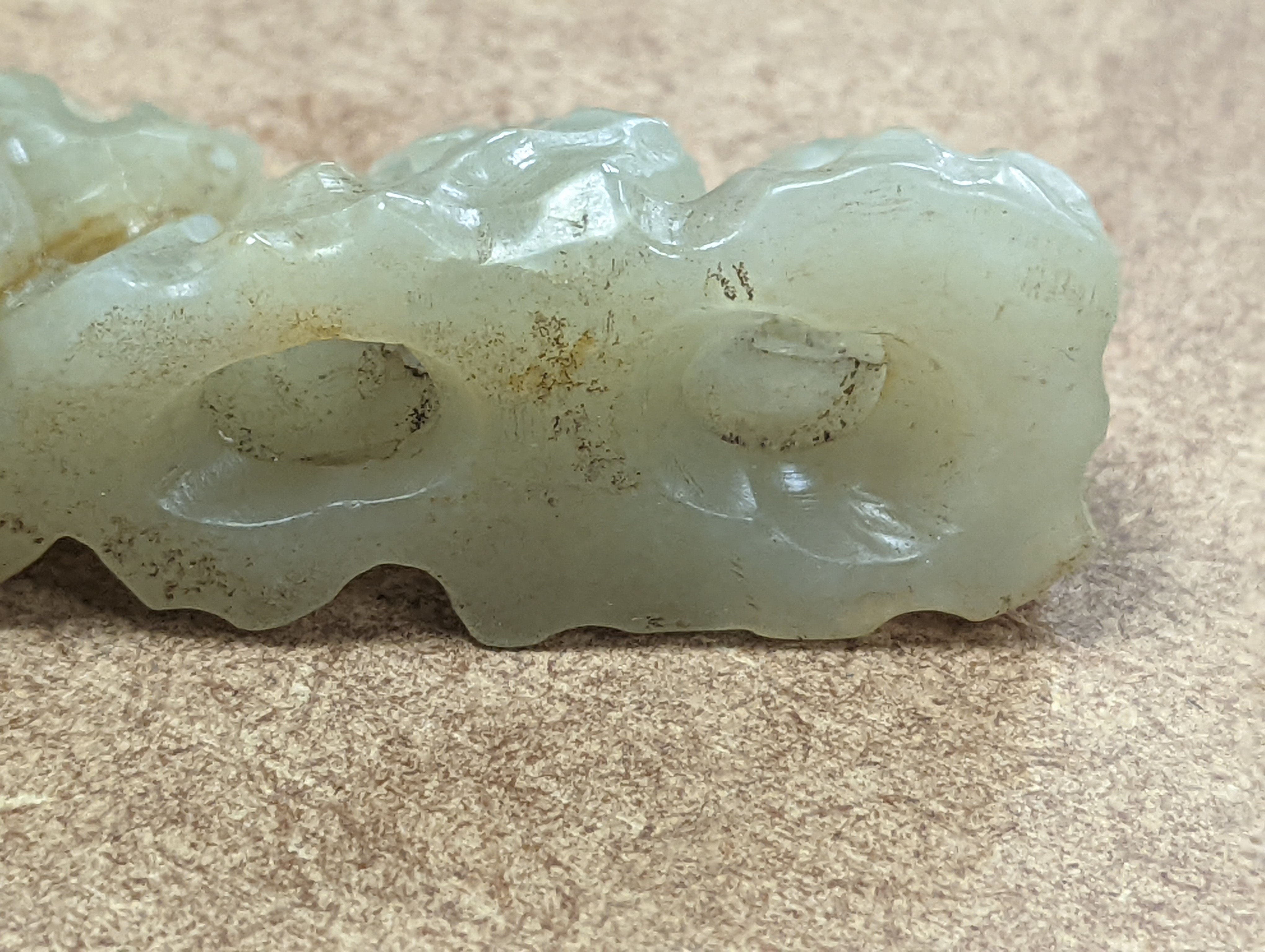 A Chinese celadon jade brush rest, 8cms wide